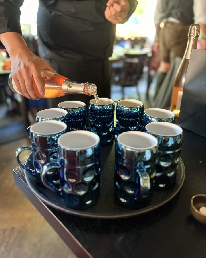 Sparkling wine being poured into the blue mugs